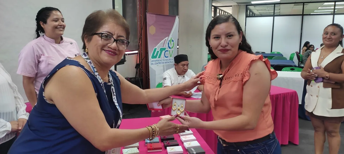 Dos trabajadoras intercambian un obsequio durante la celebración del Día de las Madres