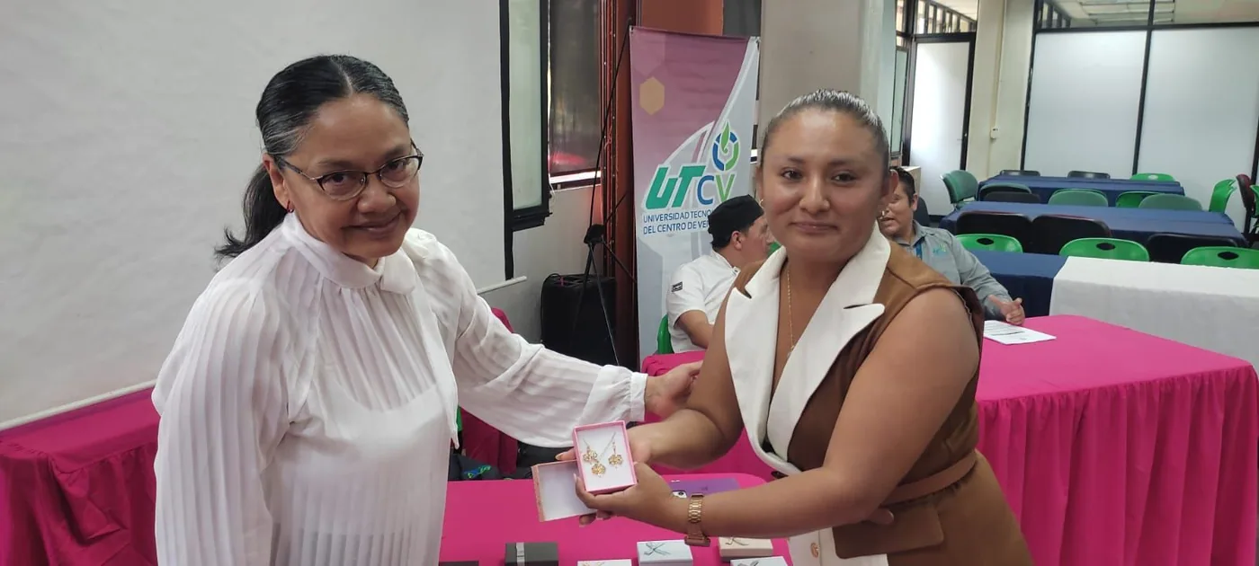 Trabajadora recibe un obsequio frente a la mesa de reconocimientos