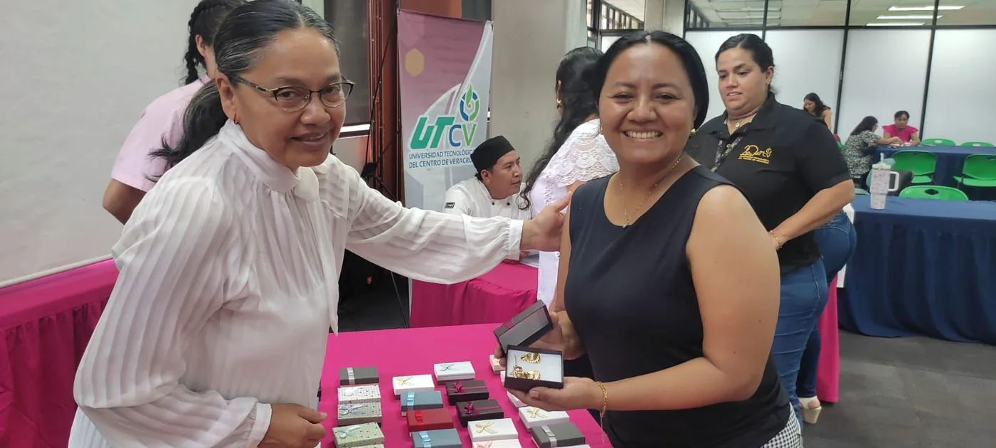 Dos integrantes de la comunidad universitaria durante la entrega de un obsequio
