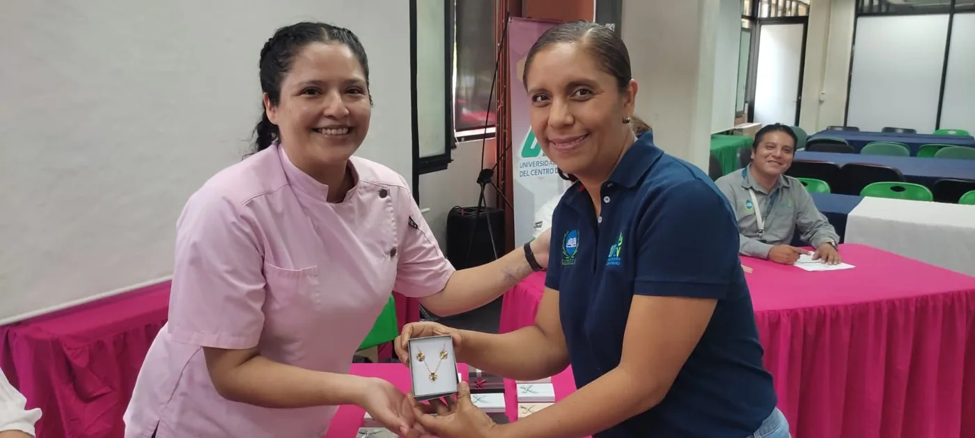 Dos trabajadoras sostienen un obsequio durante la celebración