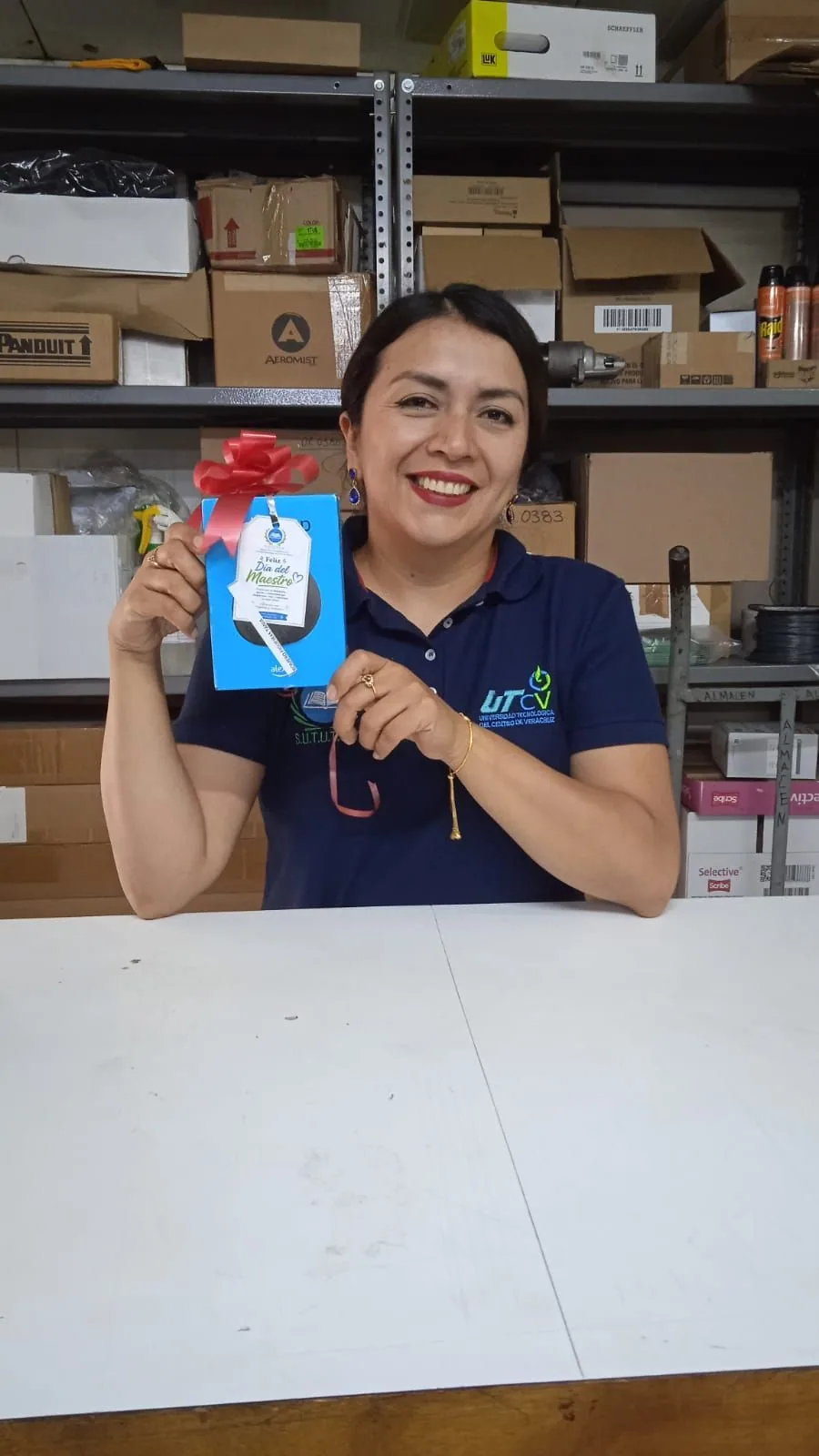 Trabajadora muestra un obsequio durante la actividad del Día del Maestro