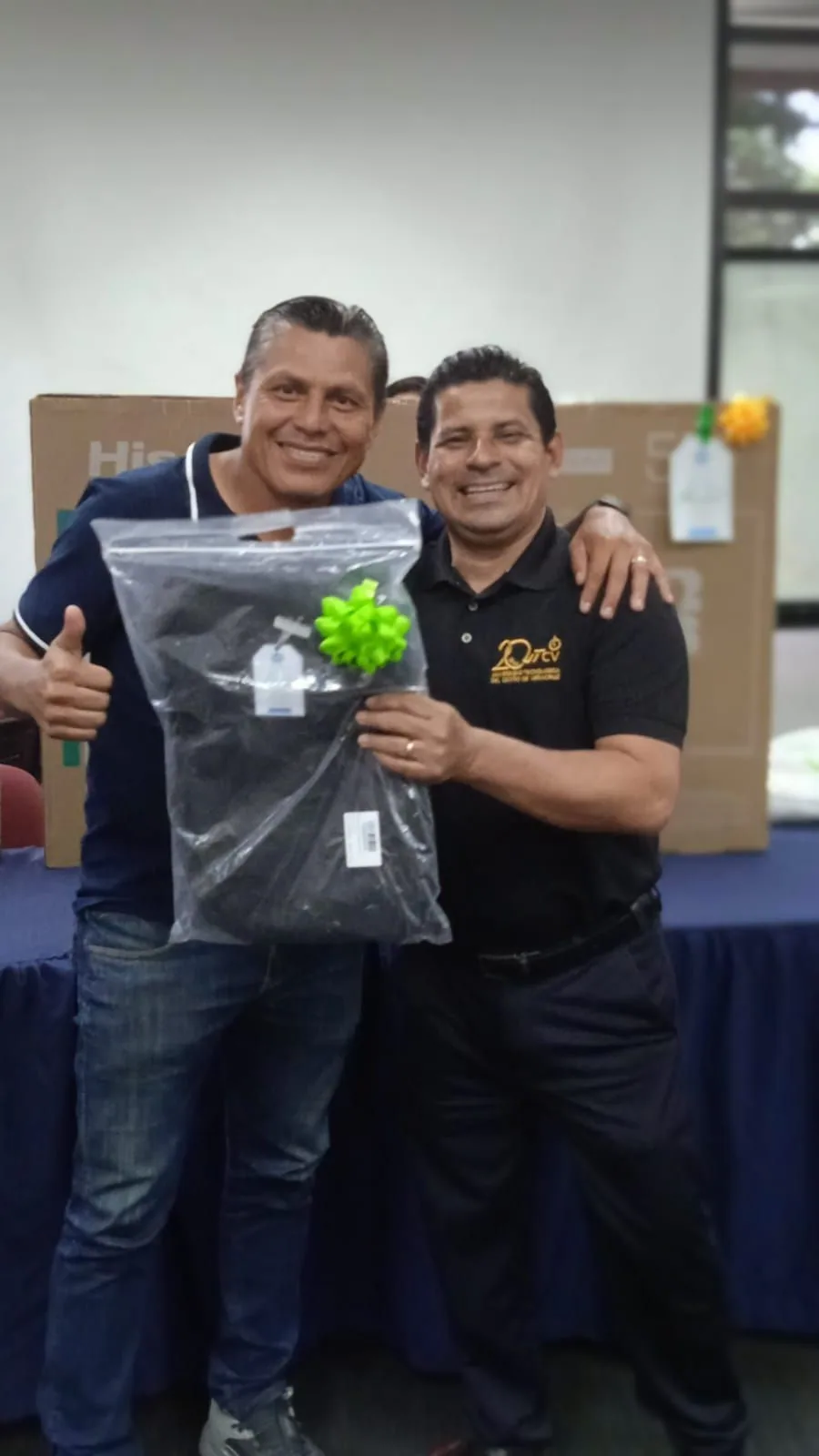 Dos trabajadores posan con un obsequio empacado durante el reconocimiento