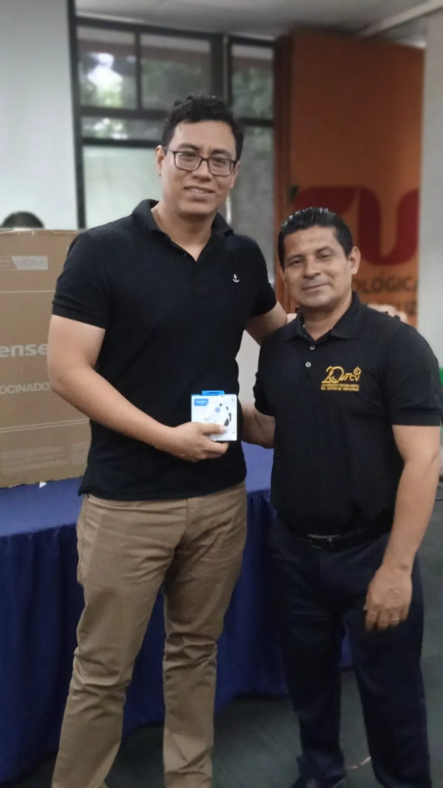 Dos integrantes de la comunidad universitaria posan con un presente