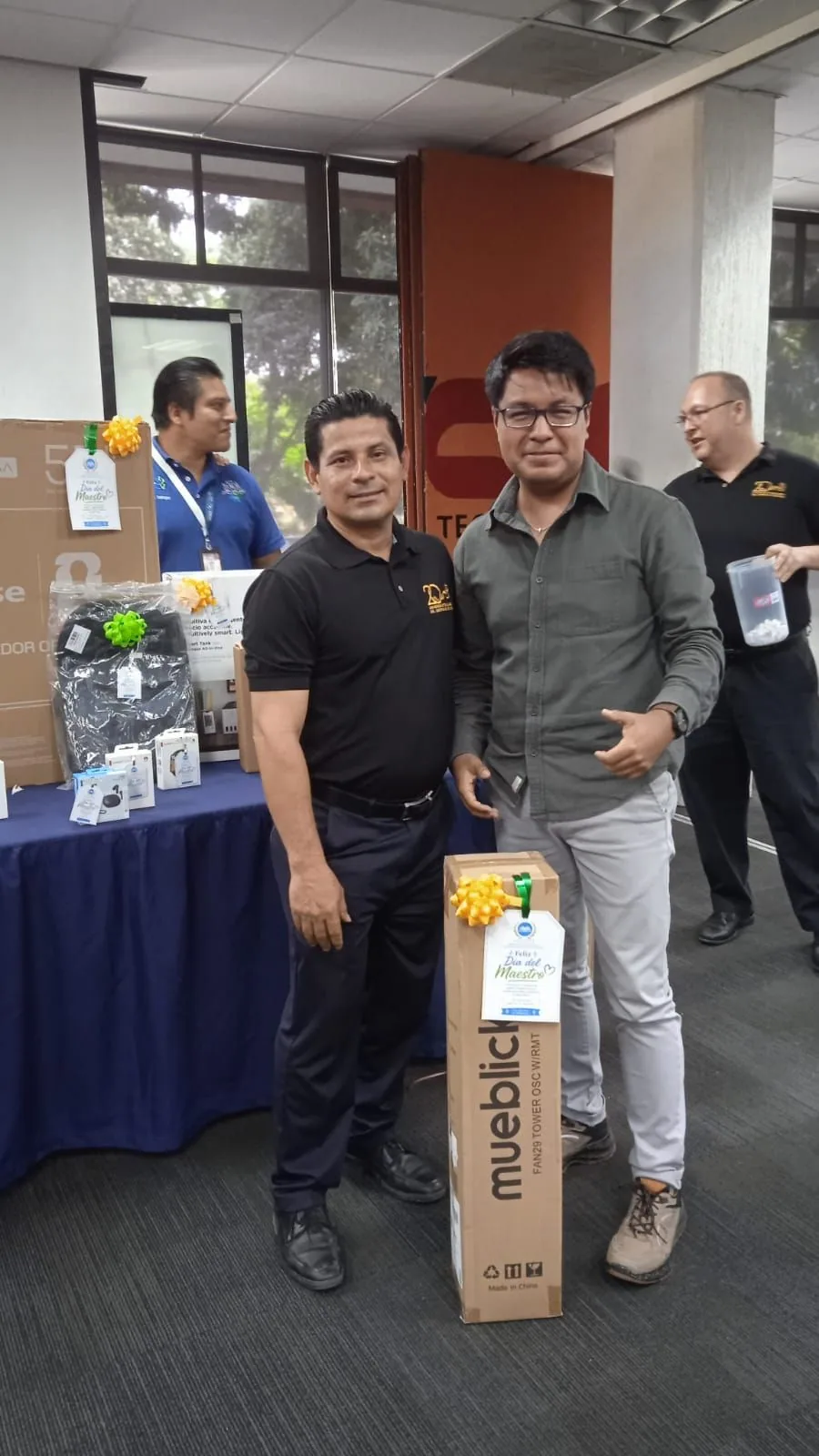 Dos trabajadores junto a un obsequio de mayor tamaño entregado en la actividad
