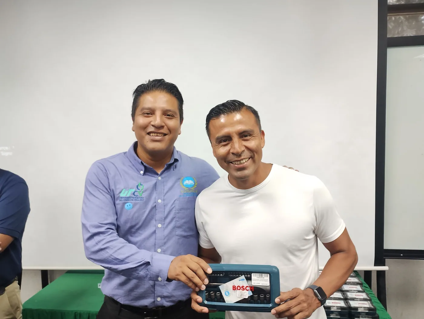 Dos trabajadores muestran un juego de herramientas entregado por el Día del Padre