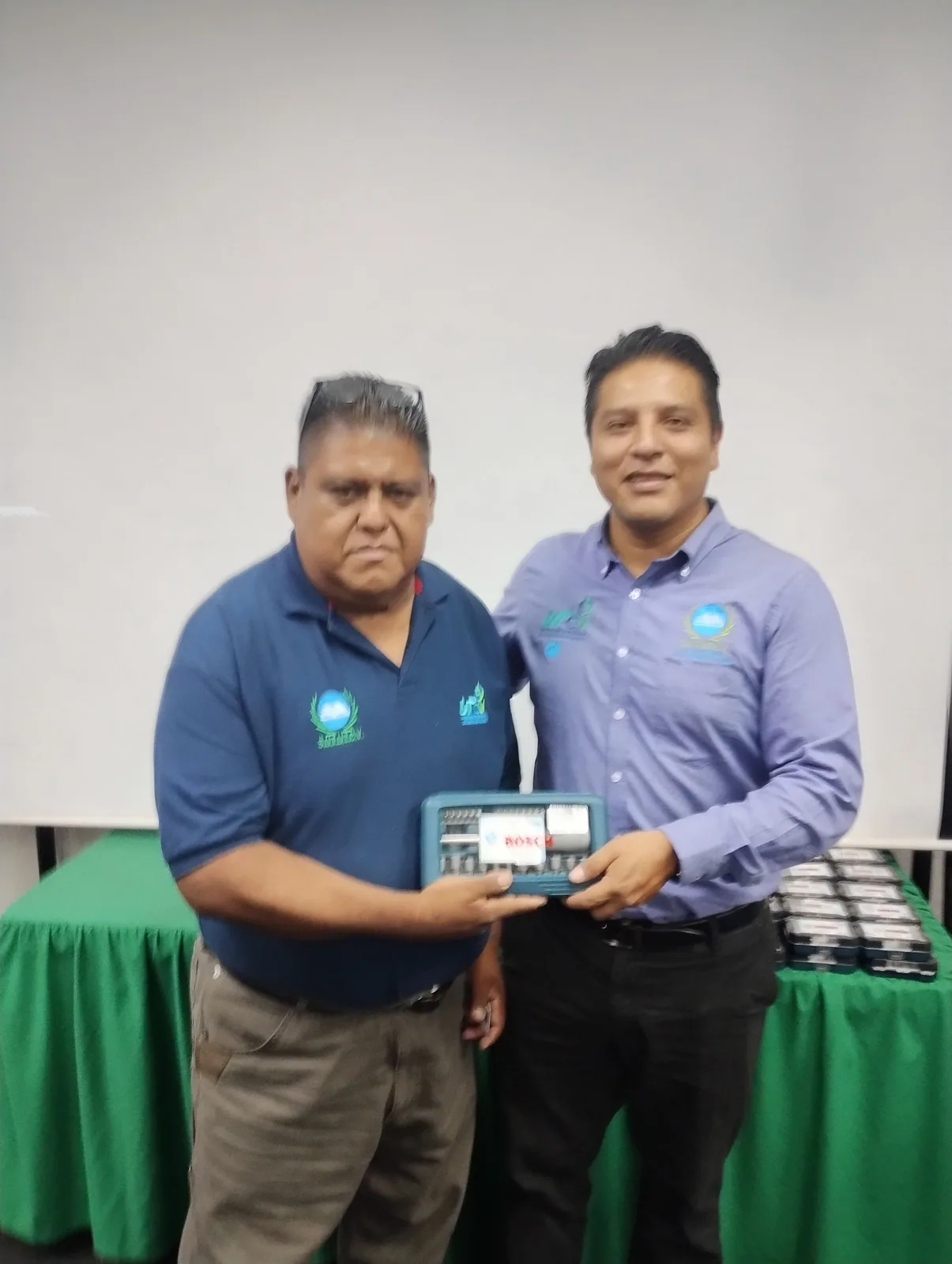 Dos integrantes de la comunidad universitaria posan con un obsequio