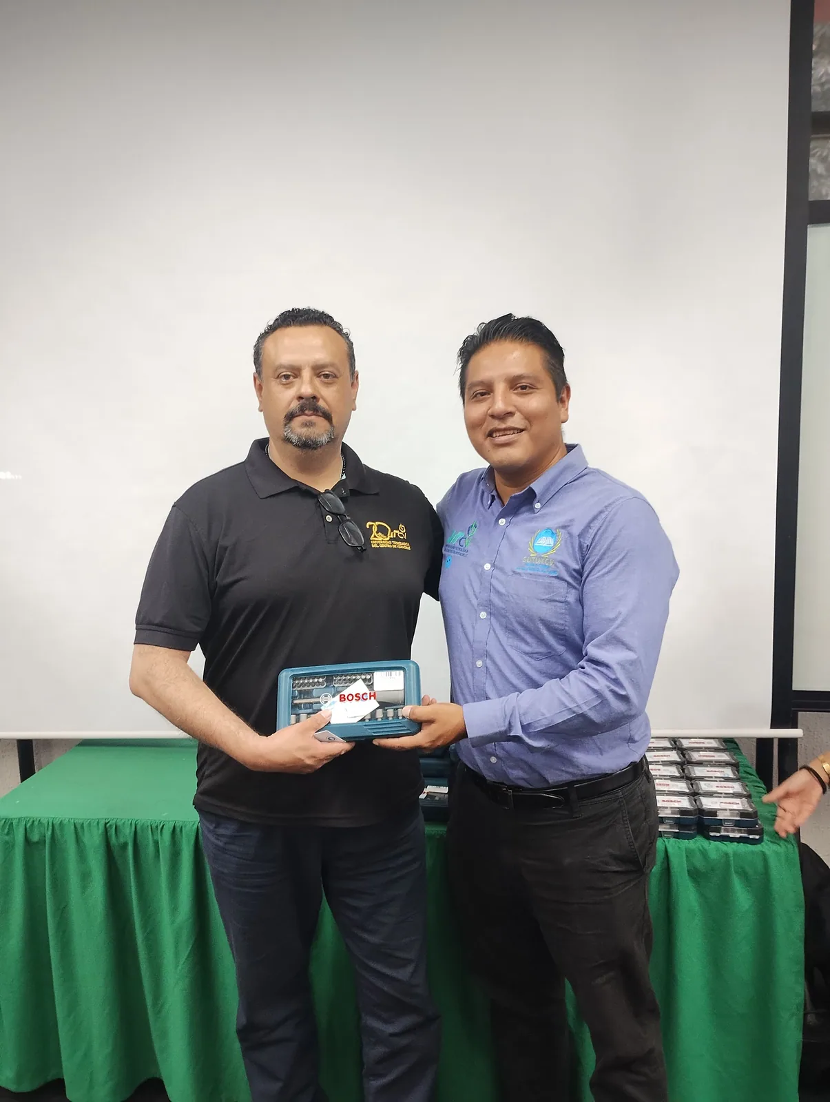 Trabajador sostiene el juego de herramientas recibido durante la celebración