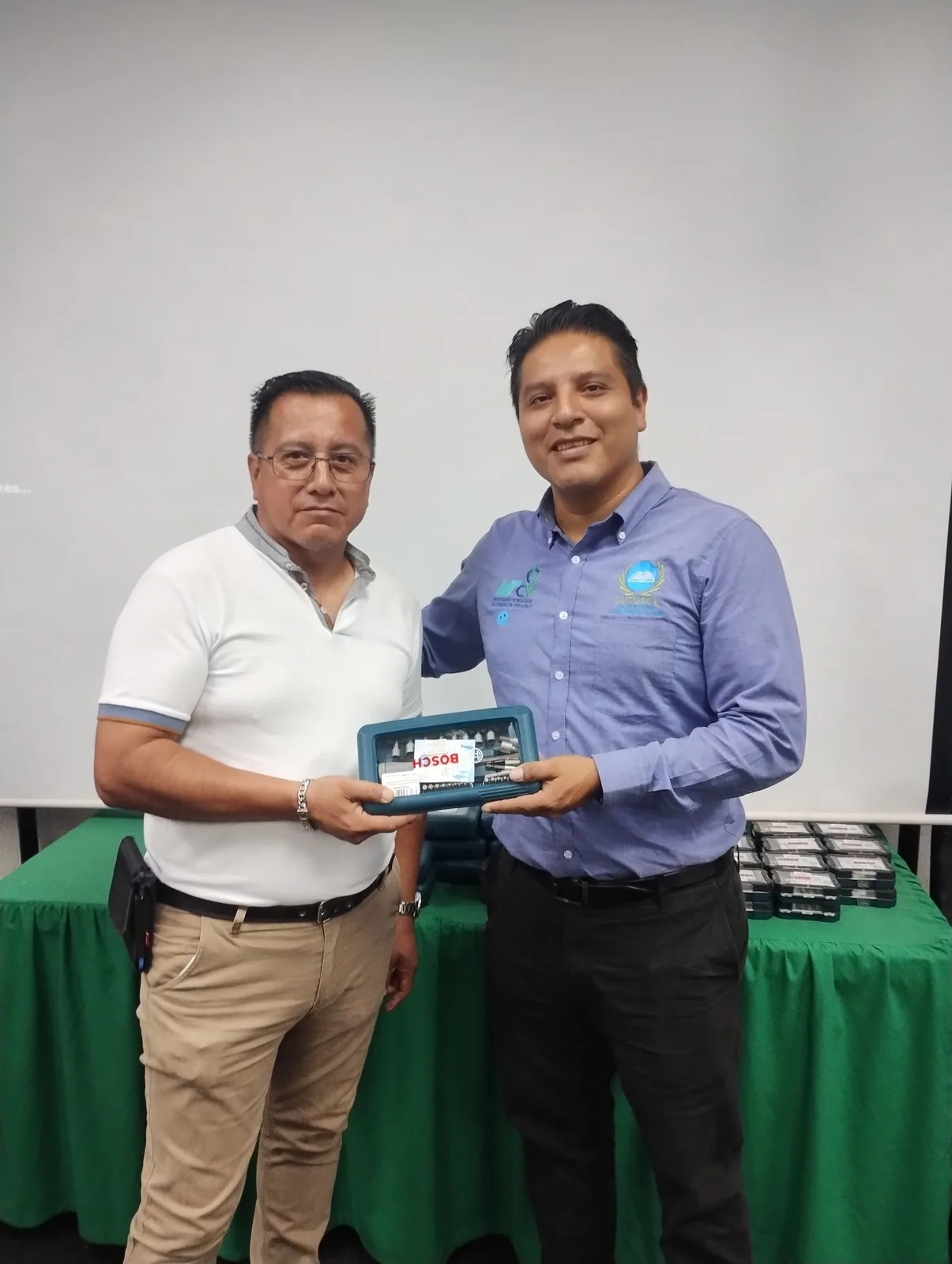 Dos trabajadores presentan un obsequio entregado por el Día del Padre
