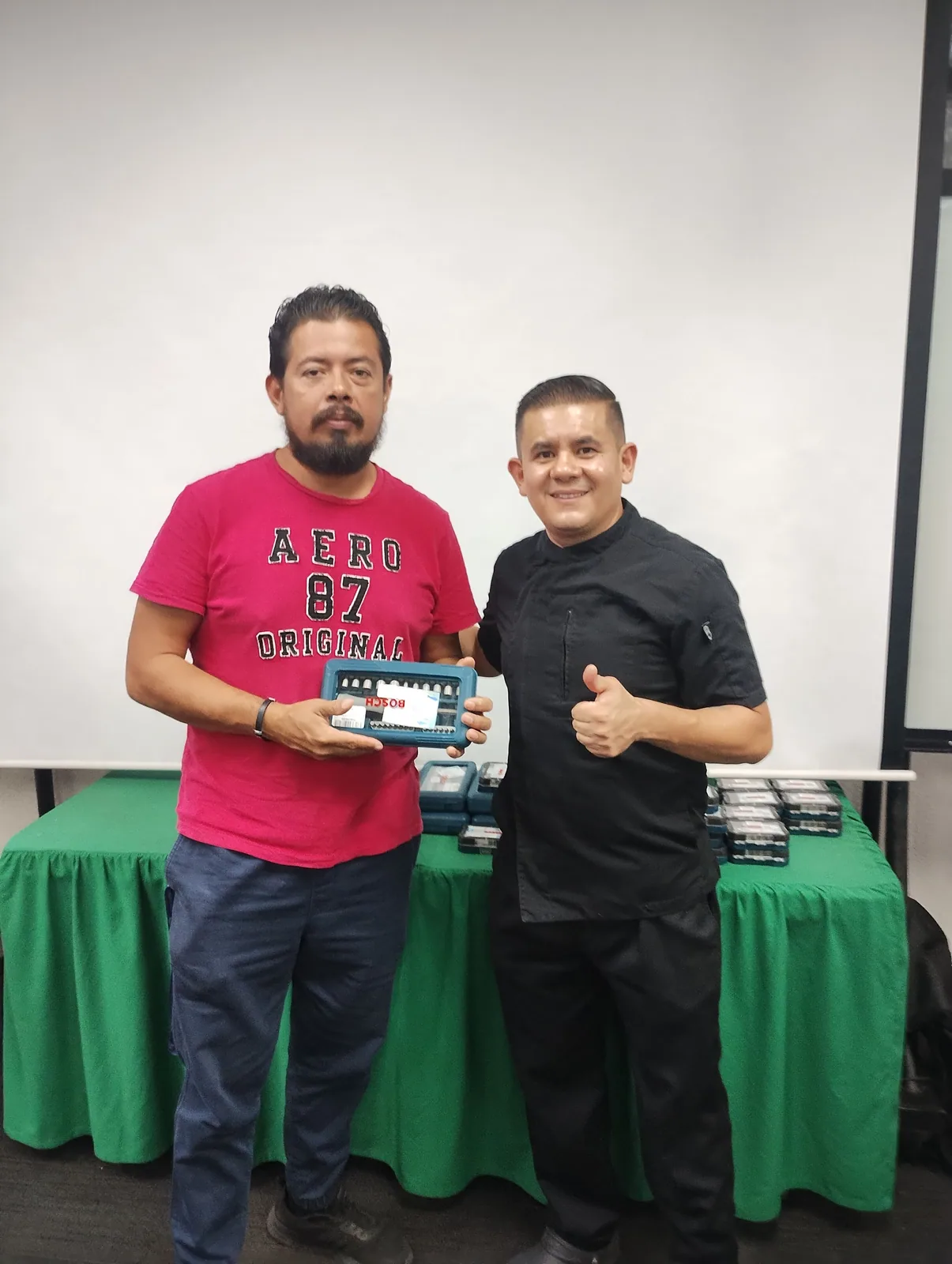 Dos trabajadores posan con el obsequio entregado durante la actividad