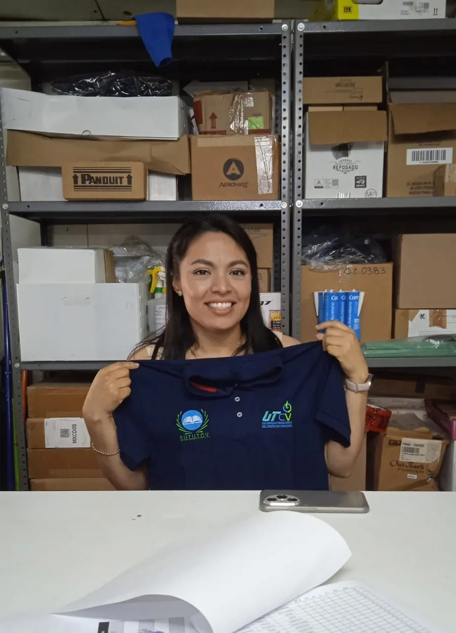 Trabajadora muestra una camisa institucional durante la entrega