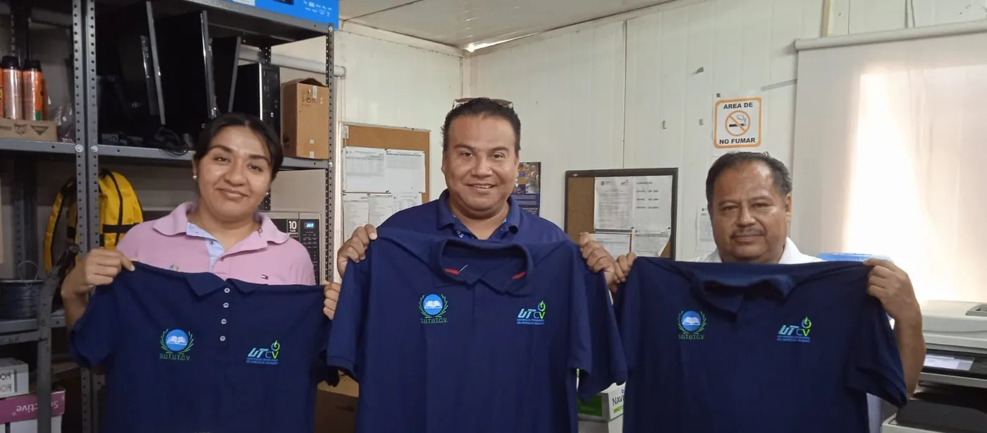Tres integrantes de la comunidad universitaria muestran camisas institucionales
