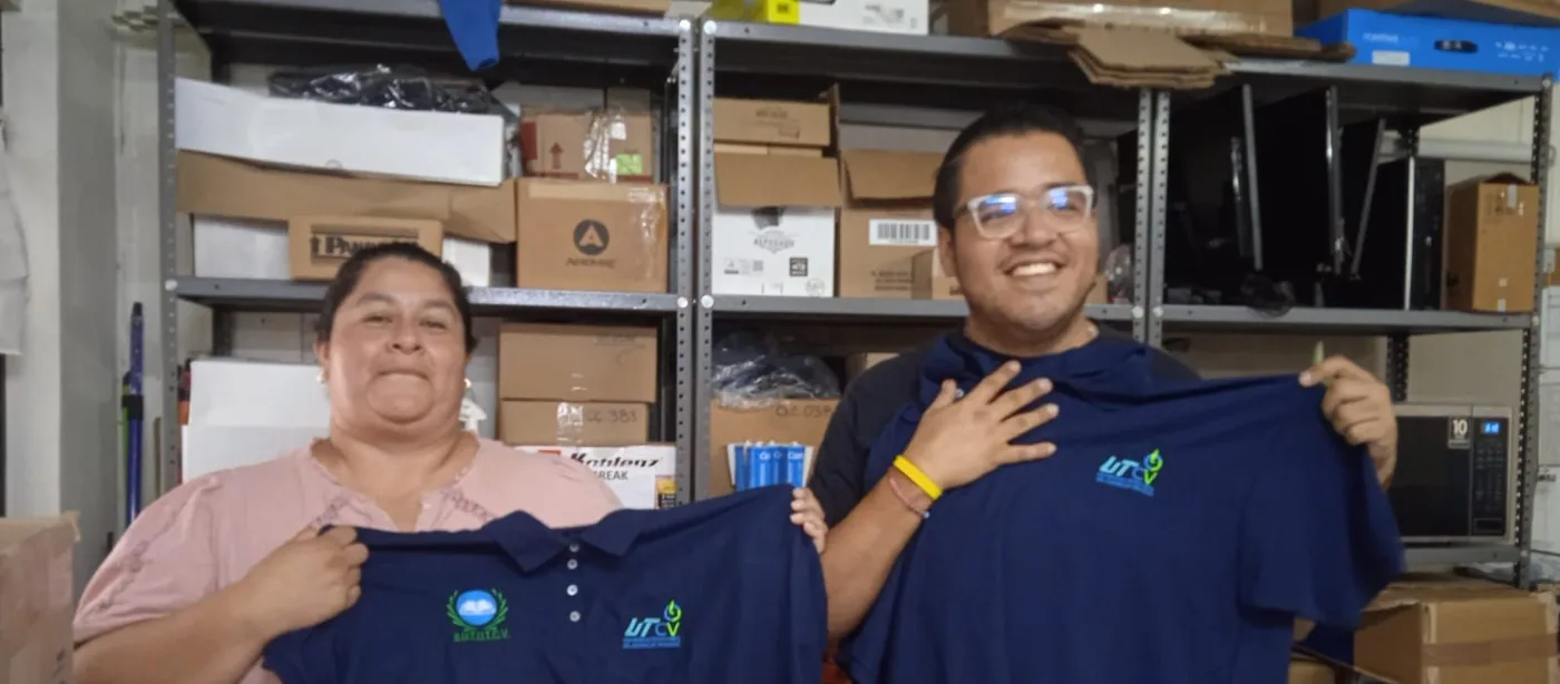 Dos trabajadoras muestran las camisas institucionales recibidas